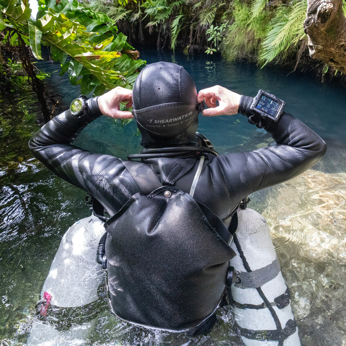 Diver wearing Shearwater Perdix 3 near a cave entrance