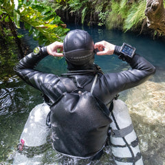 Diver wearing Shearwater Perdix 3 near a cave entrance