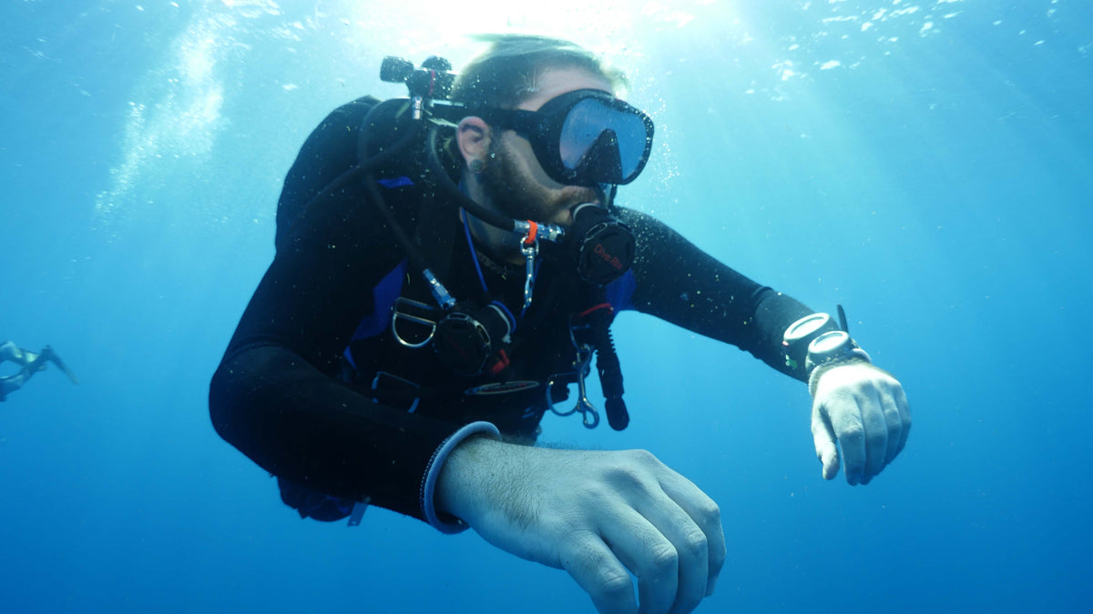 Scuba diver checking a dive computer underwater