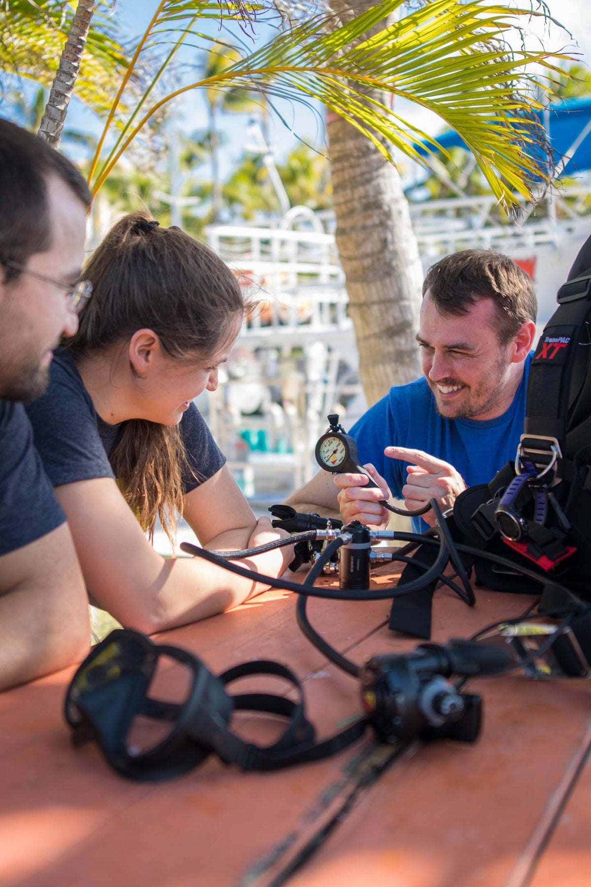 Instructor demonstrating a scuba pressure gauge and regulator to divers