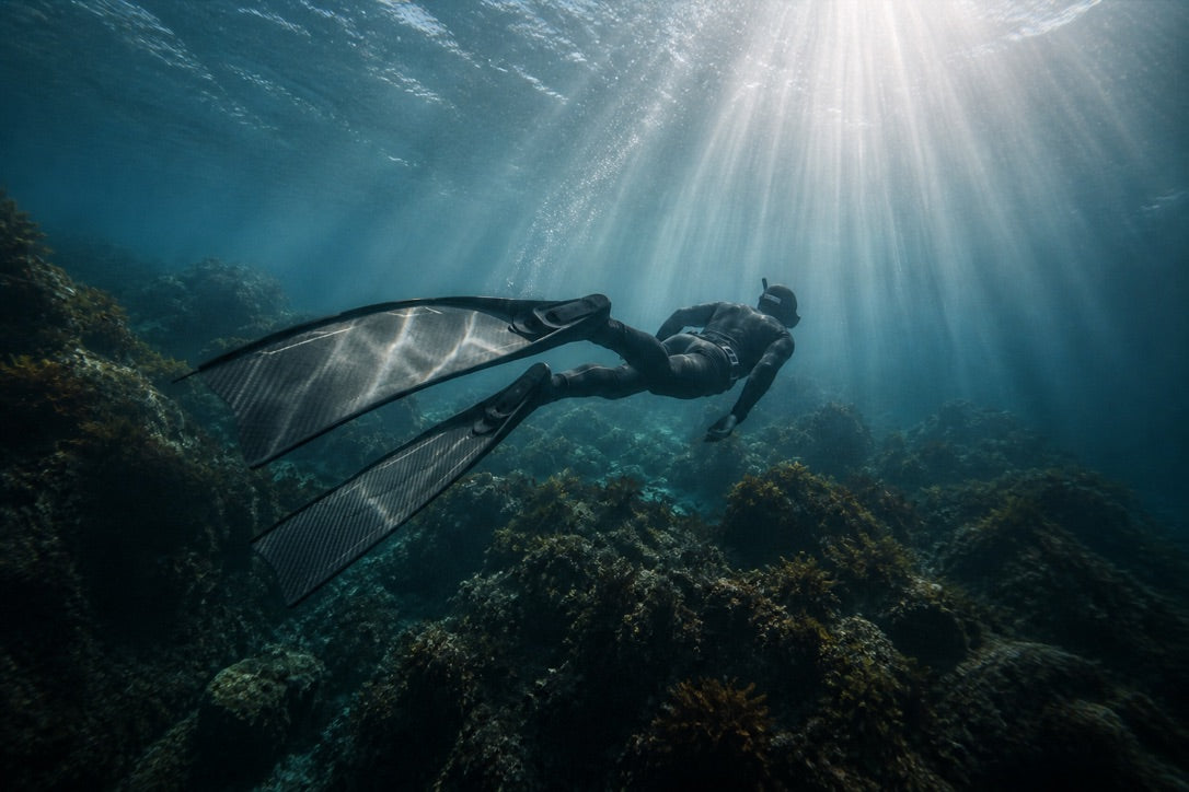 Freediver underwater wearing long freediving fins
