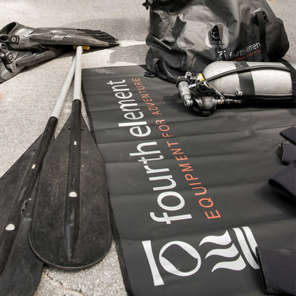 Fourth Element Changing Mat holding dive equipment beside fins and a gear bag